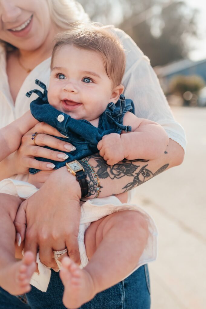 Close-up of a blue-eyed baby held by mom in soft evening light on the East Side of Santa Cruz