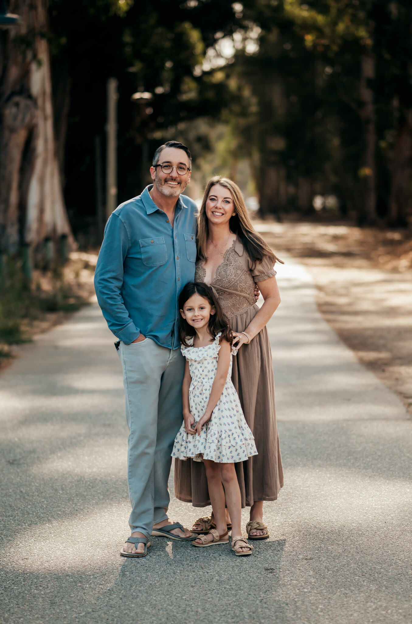 Family walking a eucalyptus-lined path during their Monterey vacation photo session