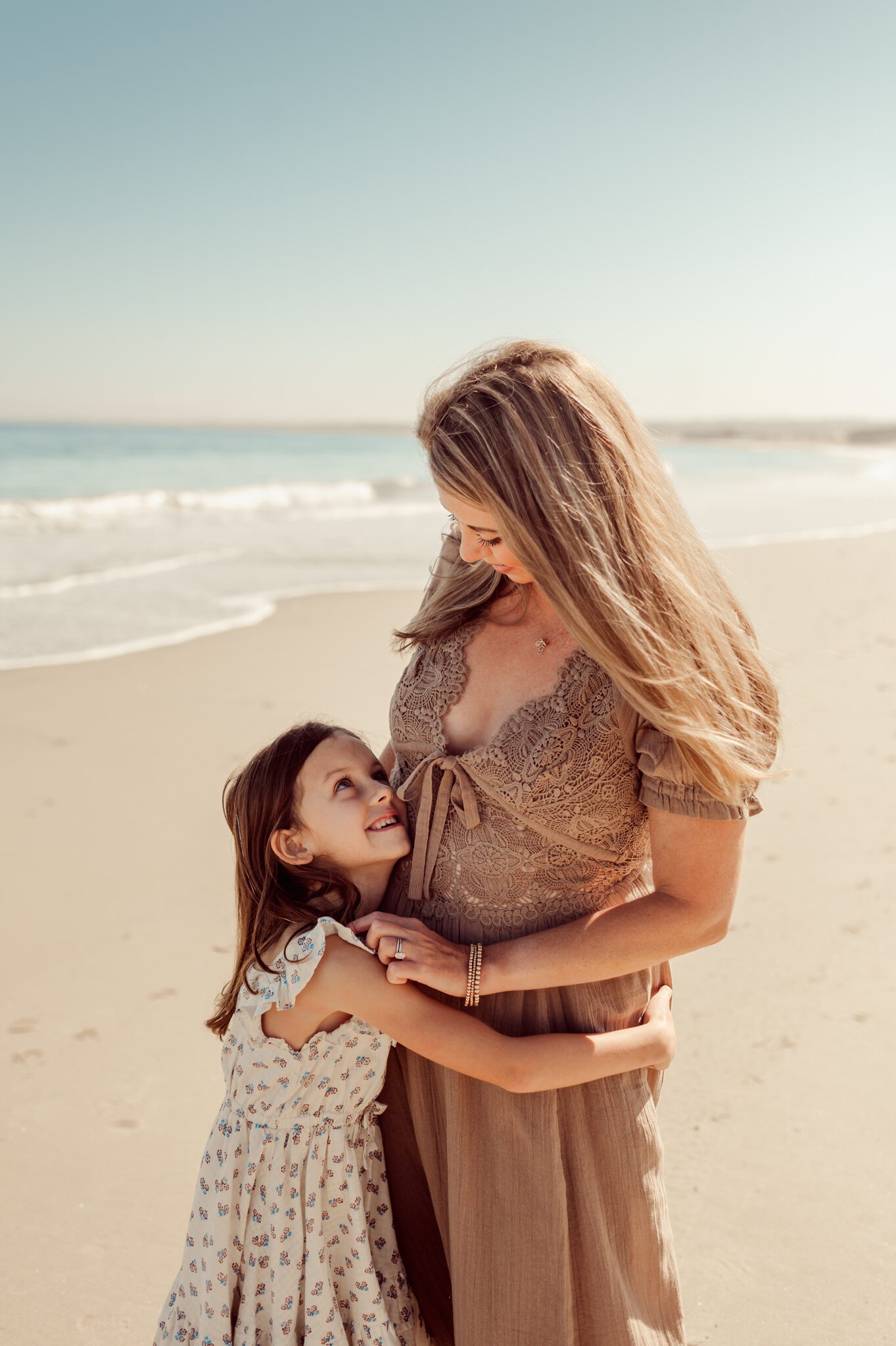 Mother holding her daughter on a Monterey beach