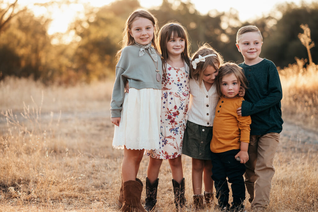 Five siblings snuggled up in the golden light on a sunny fall day.

