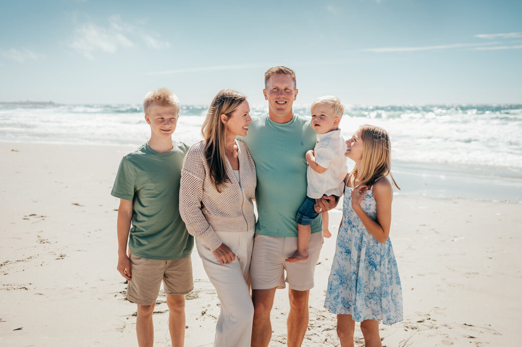 Family of five on the beach in Monterey on a sunny summer day.