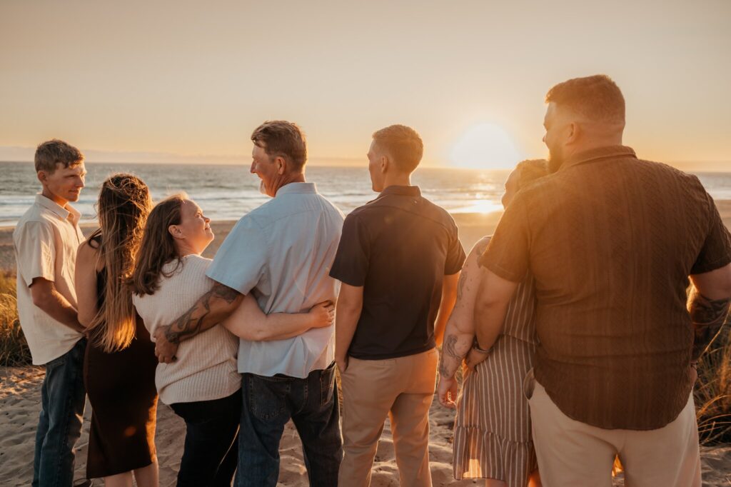 Family of seven watching the sun set over Monterey Bay from the dunes at Pajaro Dunes