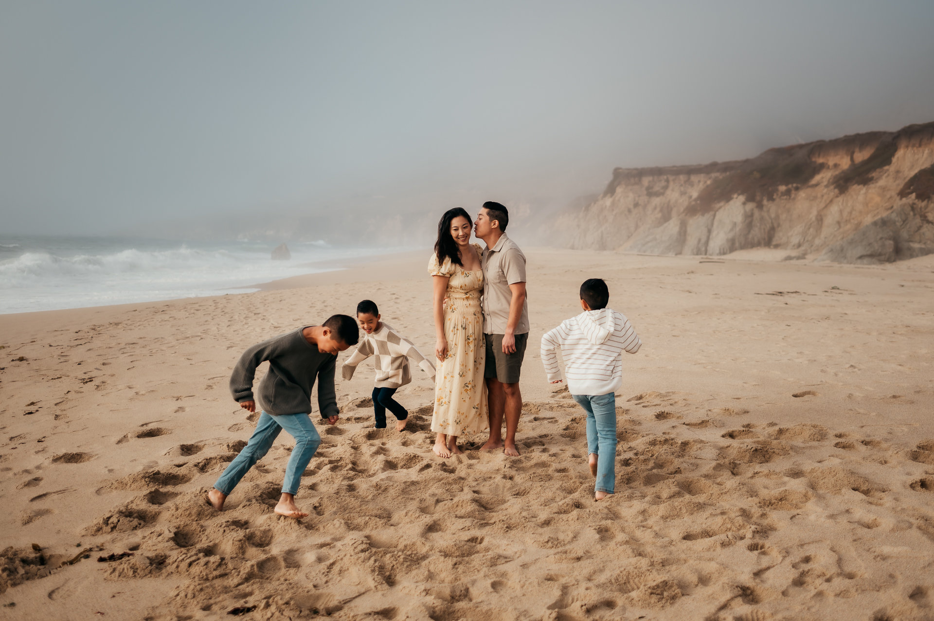 Family of five playing on a foggy beach at Garrapata State Park, Big Sur