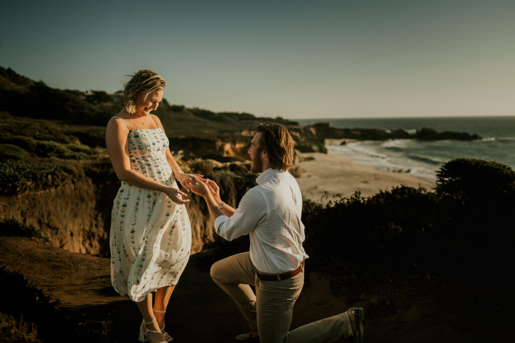 Nick on one knee proposing to Patrycja on the cliffs at Garrapata State Park in Big Sur at sunset
