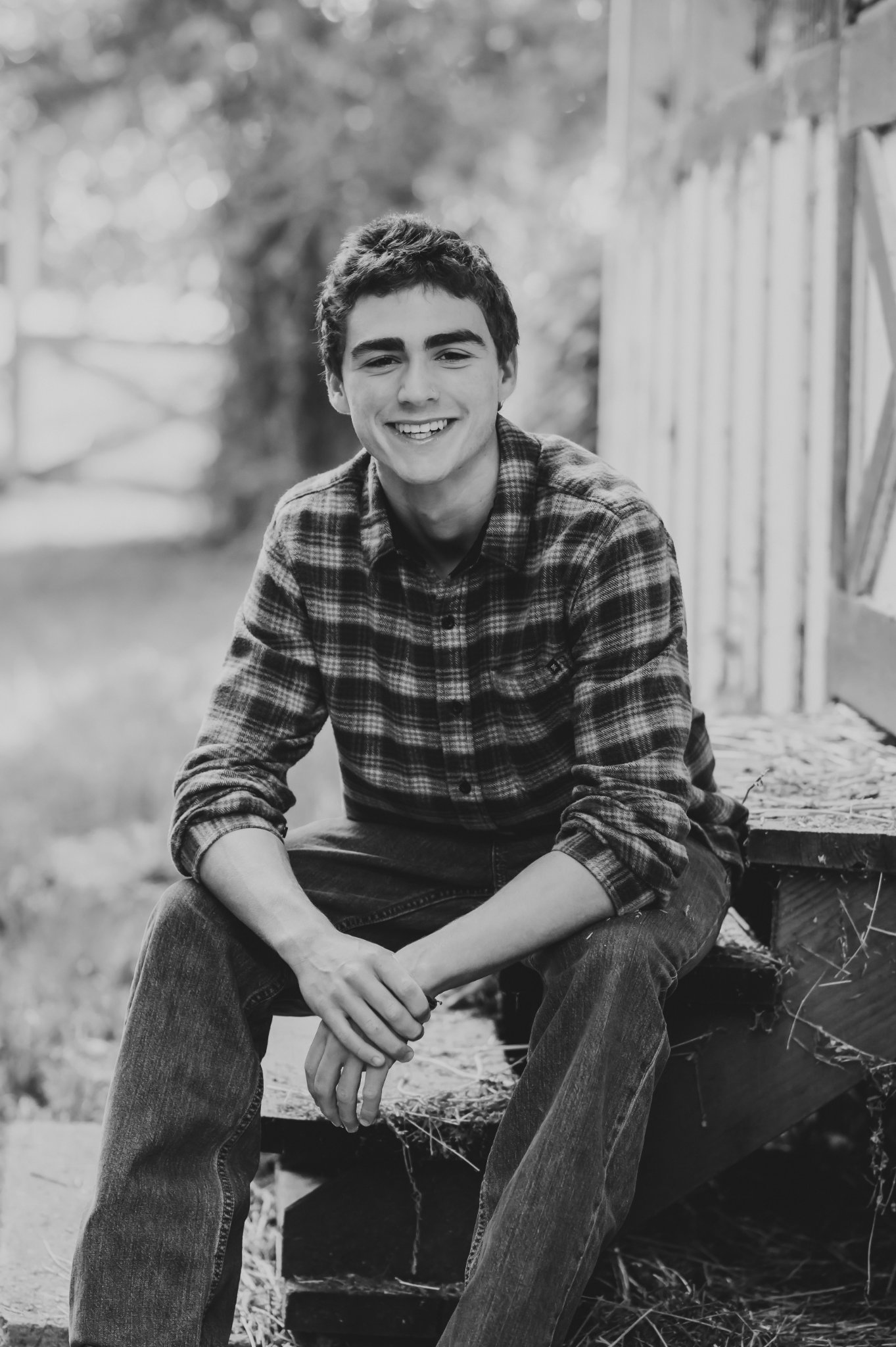 Black and white portrait of a smiling high school senior on barn steps, Carmel senior photos