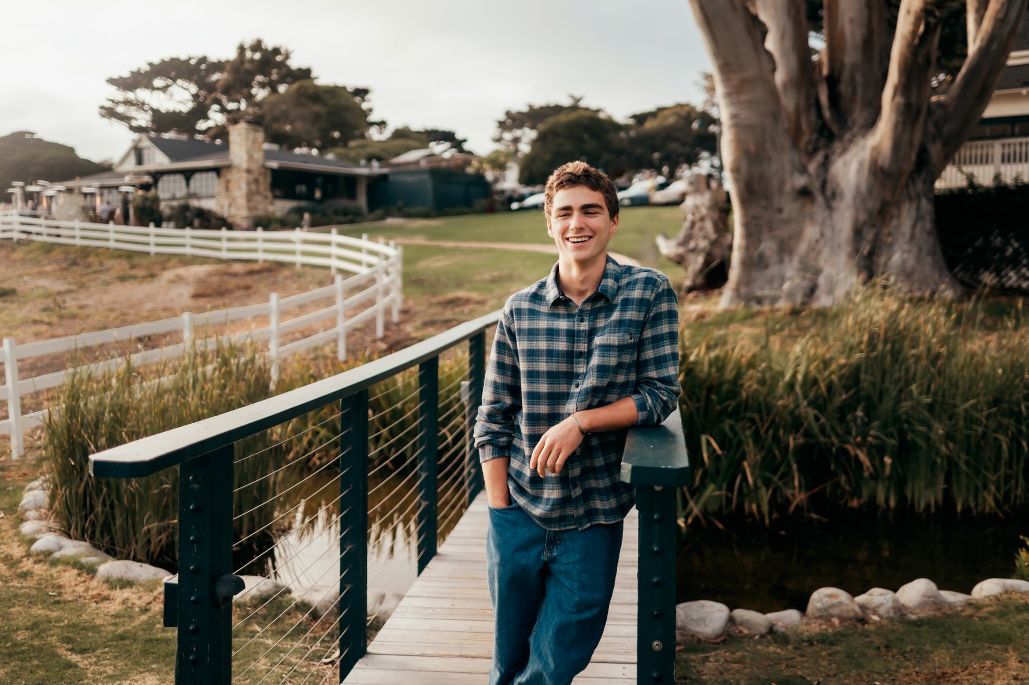 Senior boy laughing on the wooden bridge by the pond at Mission Ranch, Carmel-by-the-Sea